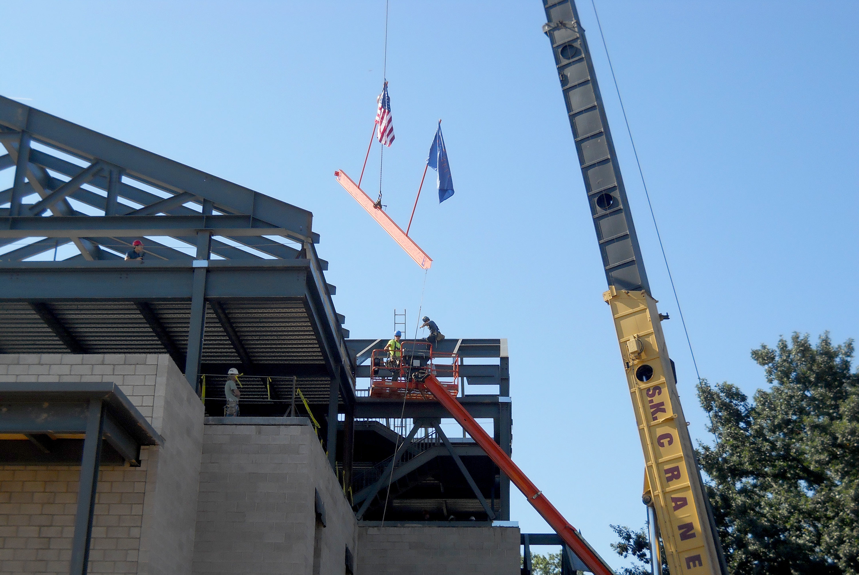 The final piece of steel is flown into place at the Academic West building of Bucknell University.