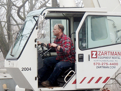 A Zartman Construction crane operator works one of the team