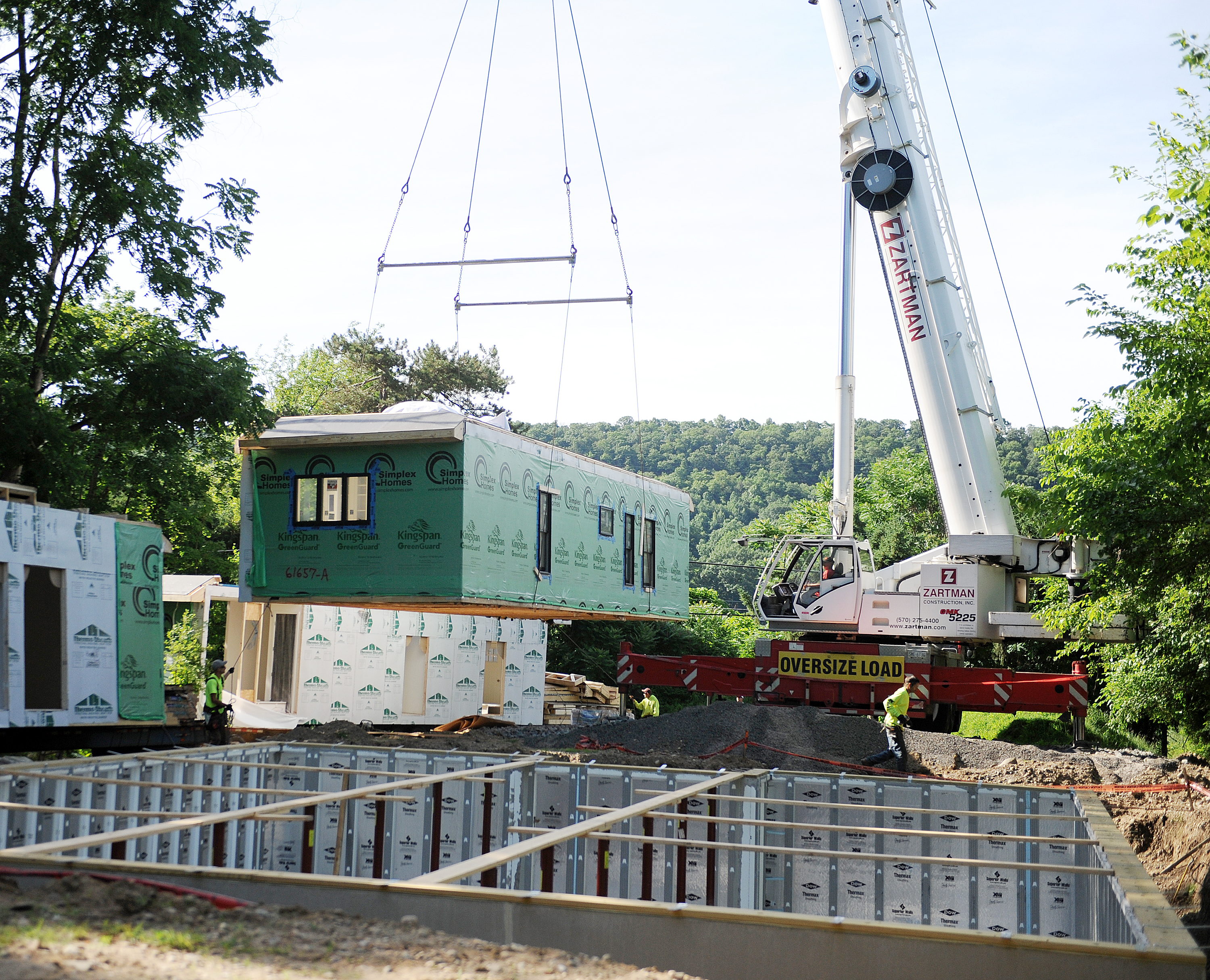 A section of modular home is set with a 140 ton crane.