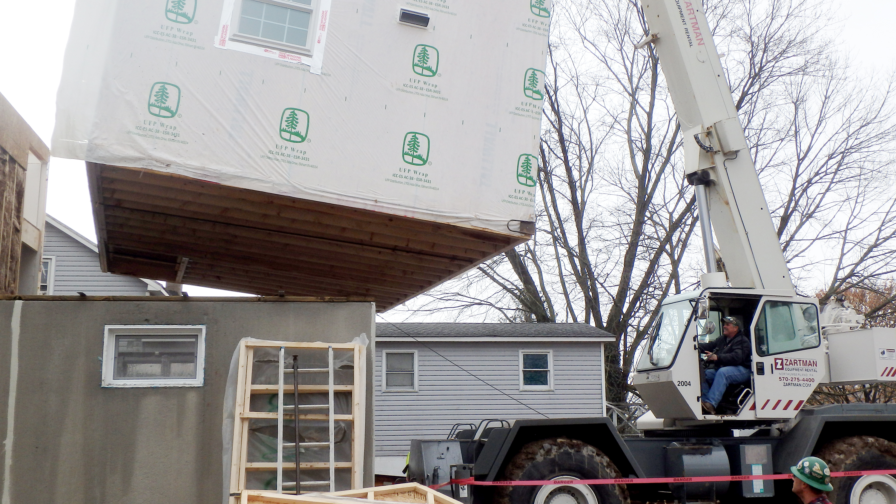 A section of modular home is set into place.