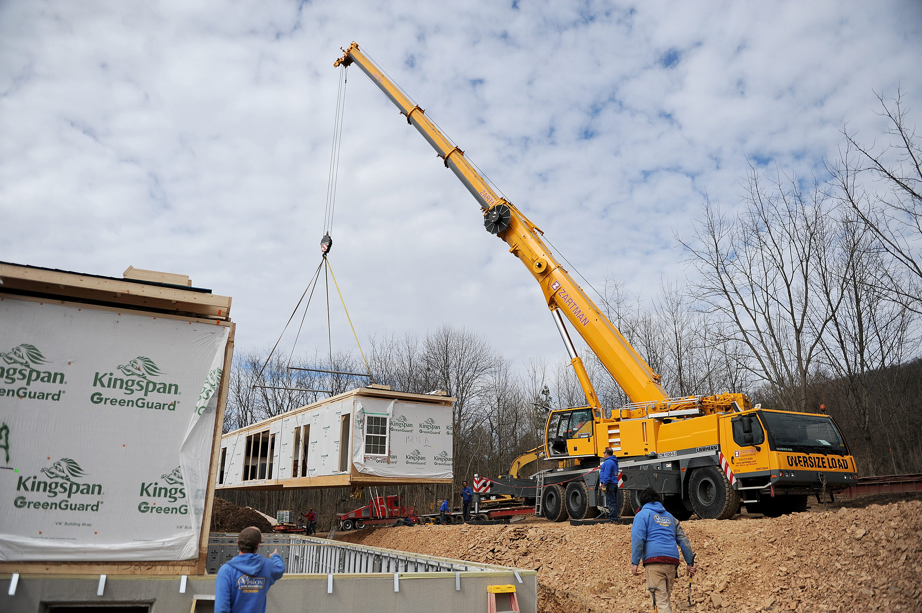 A section of modular home is set with a 140 ton crane.