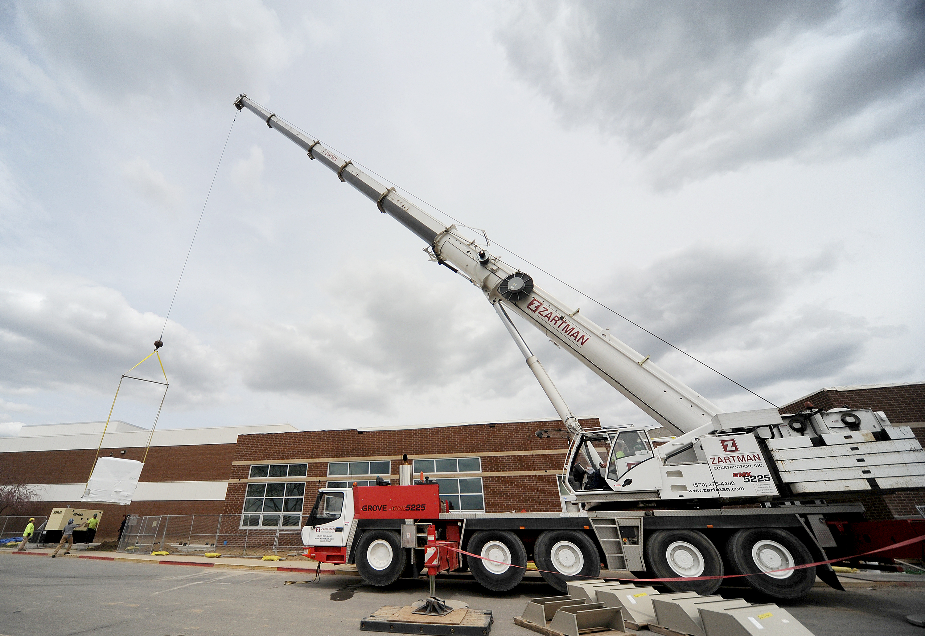 A piece of HVAC equipment is set into place with a 225 ton crane.