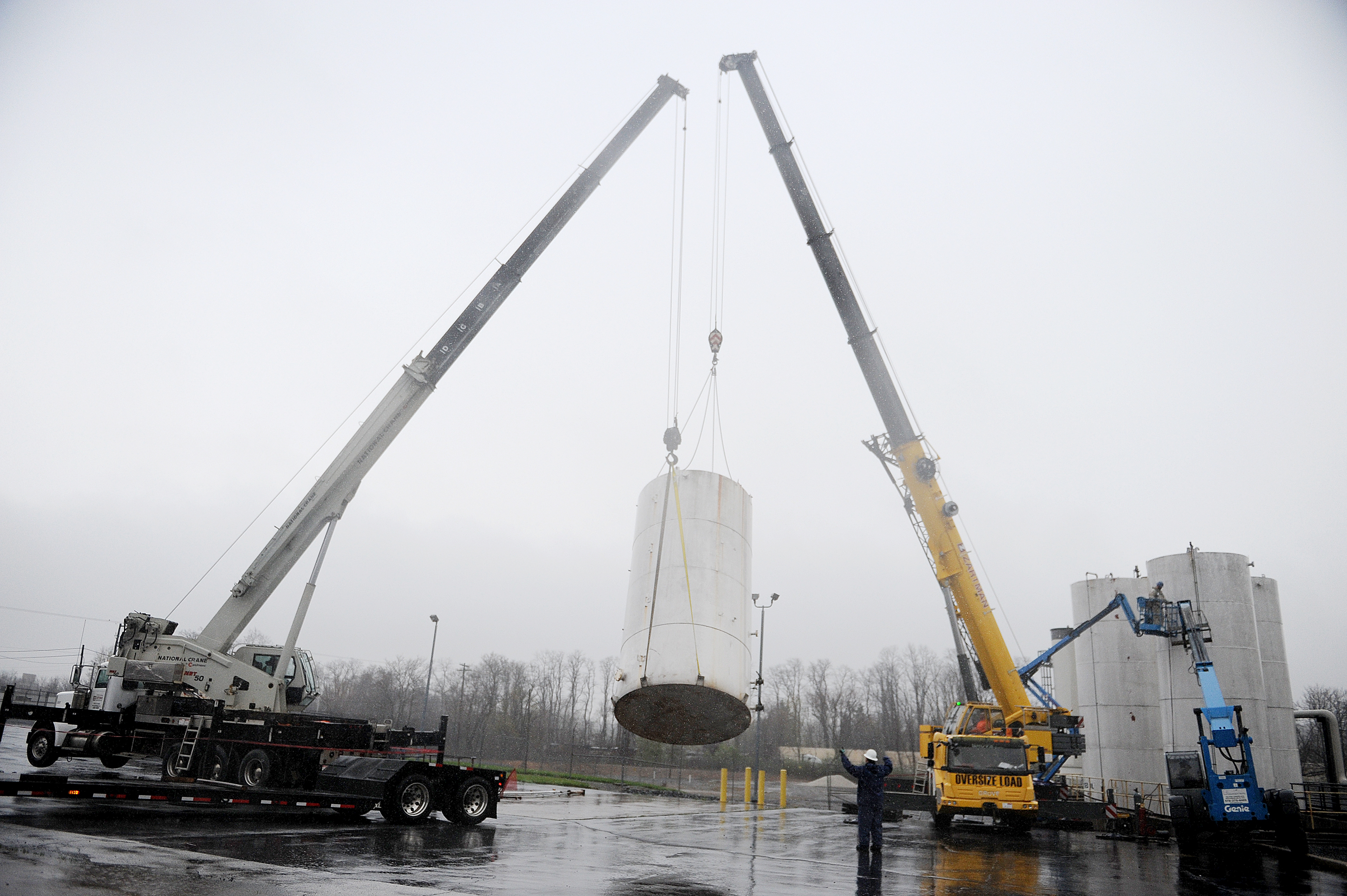 50 ton and 100 ton cranes pick-up a tank and place it on a trailer bed.