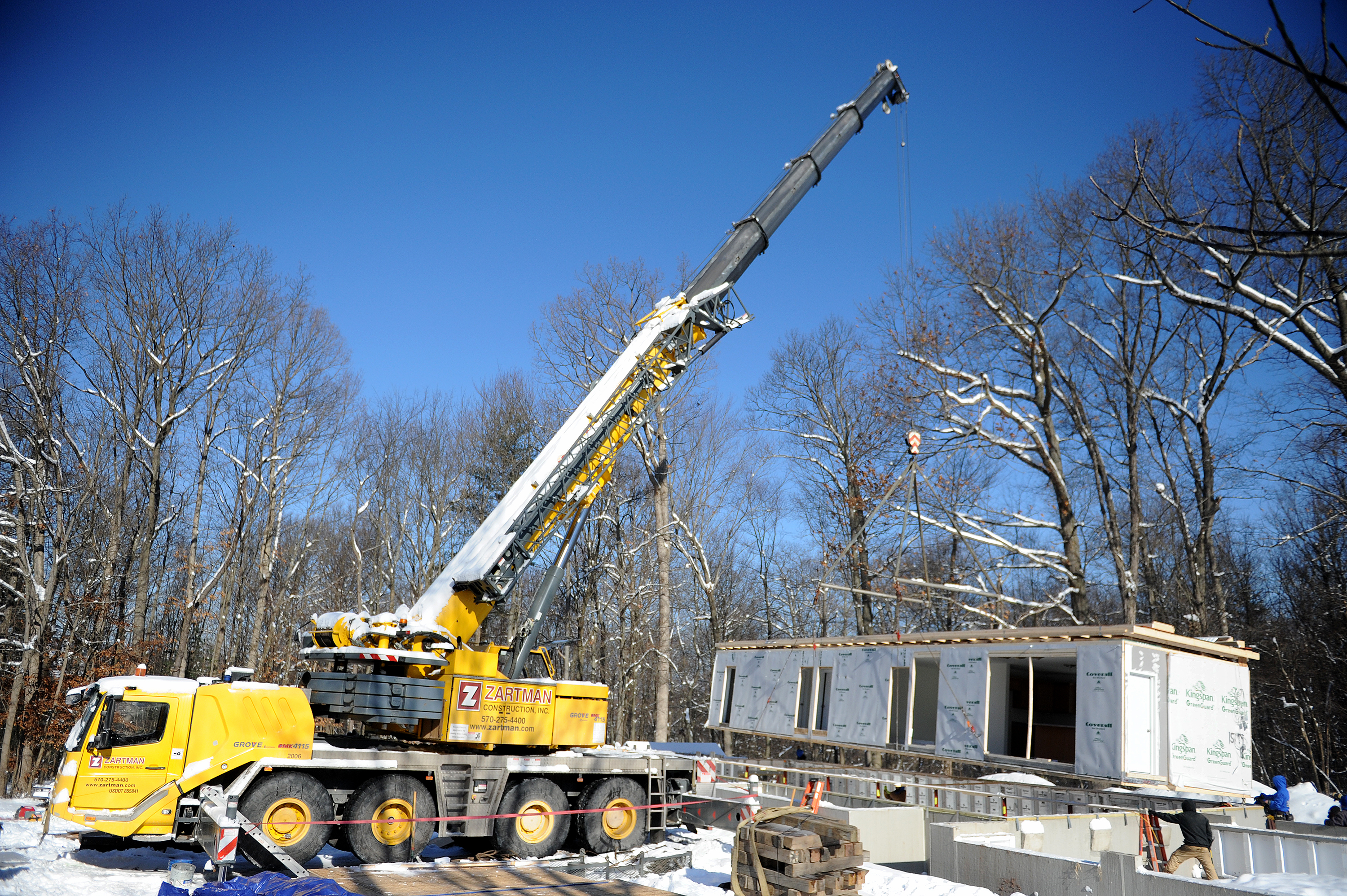 A section of modular home is set into place.