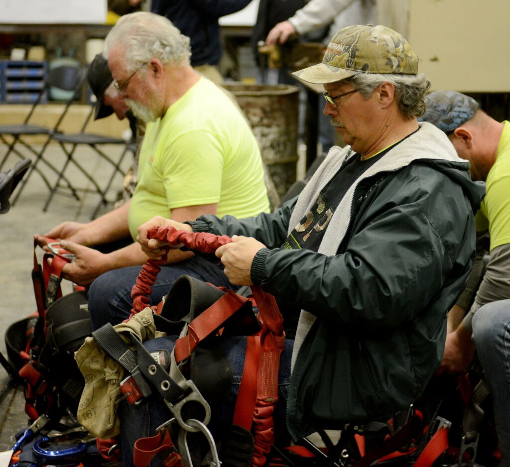 Myron Yoder and Dennis Kuczynski inspect fall protection harnesses during Zartman Construction's safety training.